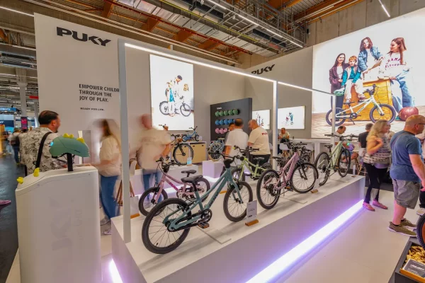 Zu sehen ist ein Messestand mit Kinderfahrrädern.